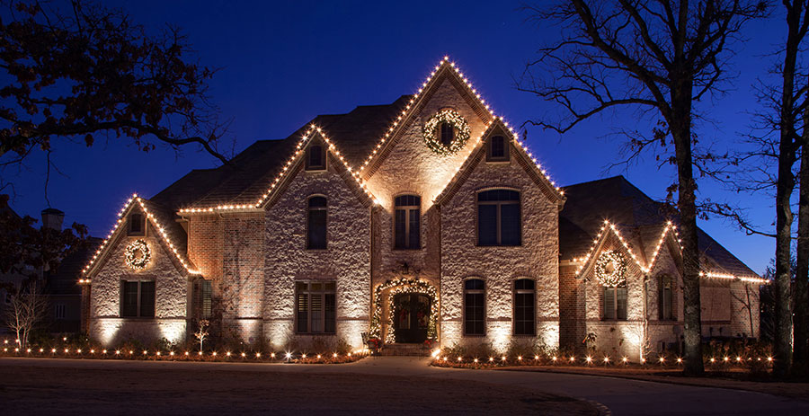 Holiday light display on an Austin residence with lit trees